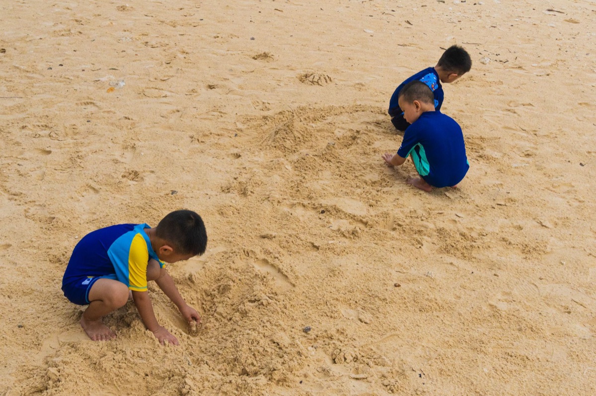 Kinderen spelen op zand in Phuket