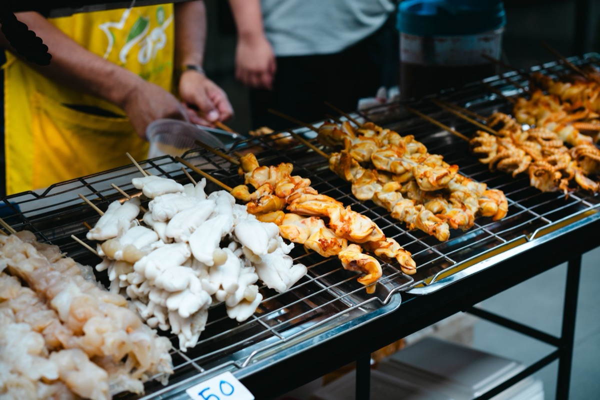 thai street food vendor with bamboo skewers