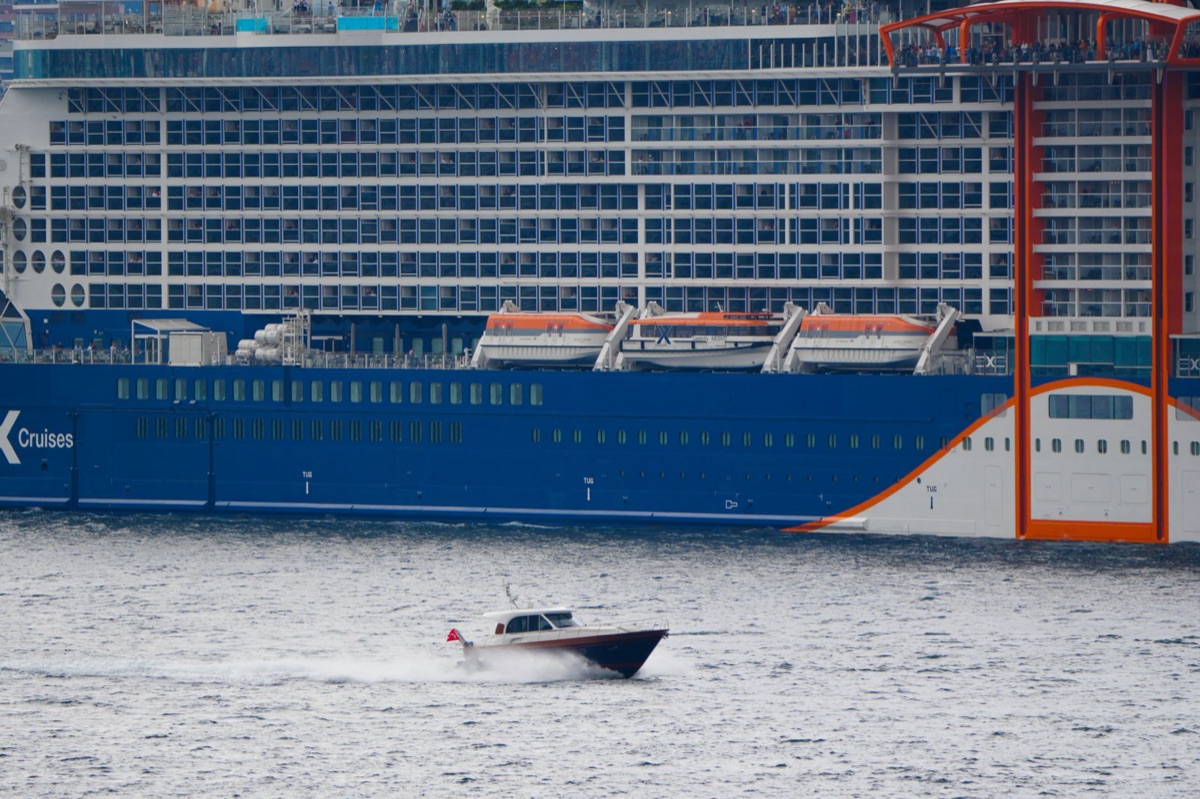 Speedboat and cruise ship side by side in tropical water