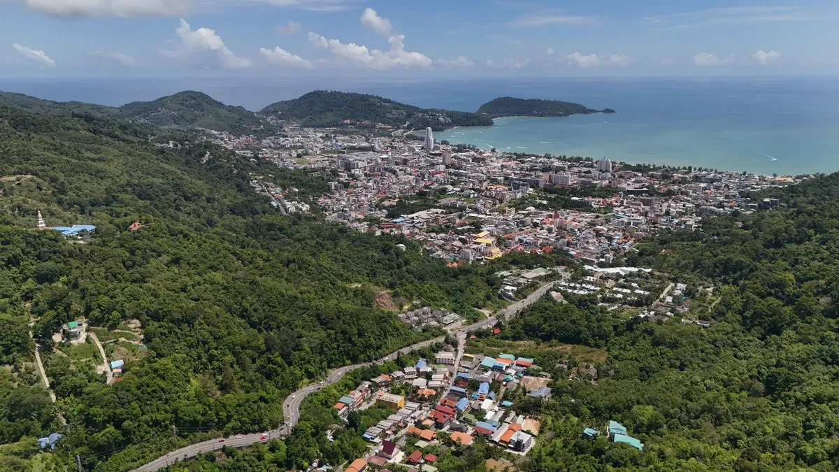 Stunning aerial view of Patong Beach and cityscape on a sunny day in Phuket, Thailand.
